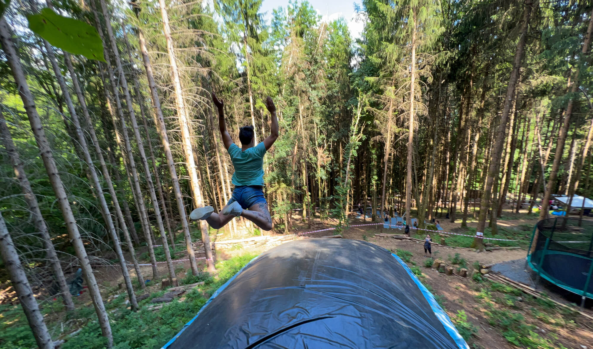 Personne sautant dans une forêt.