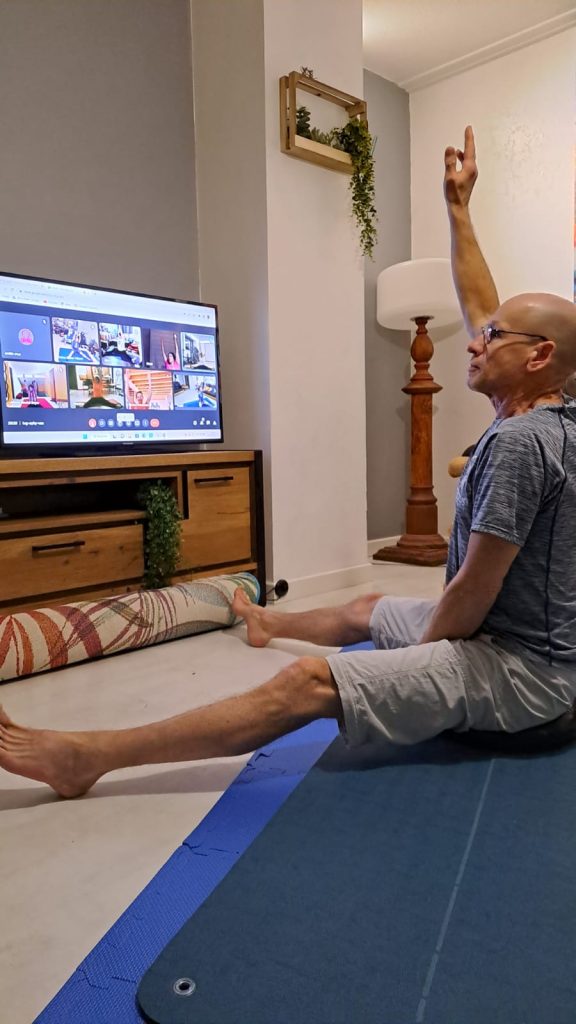 Homme fait du yoga devant la télé.