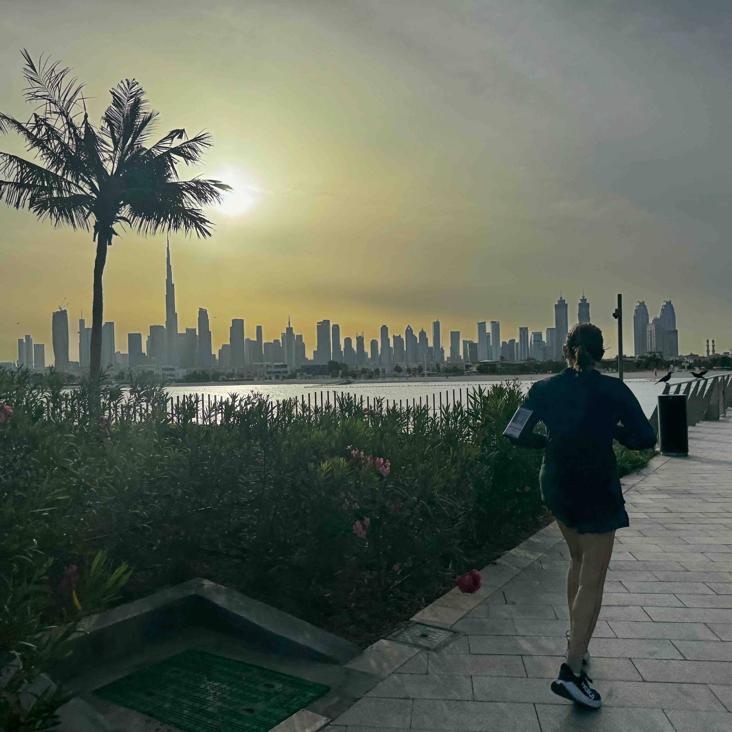 Coureur au coucher du soleil avec vue sur ville.