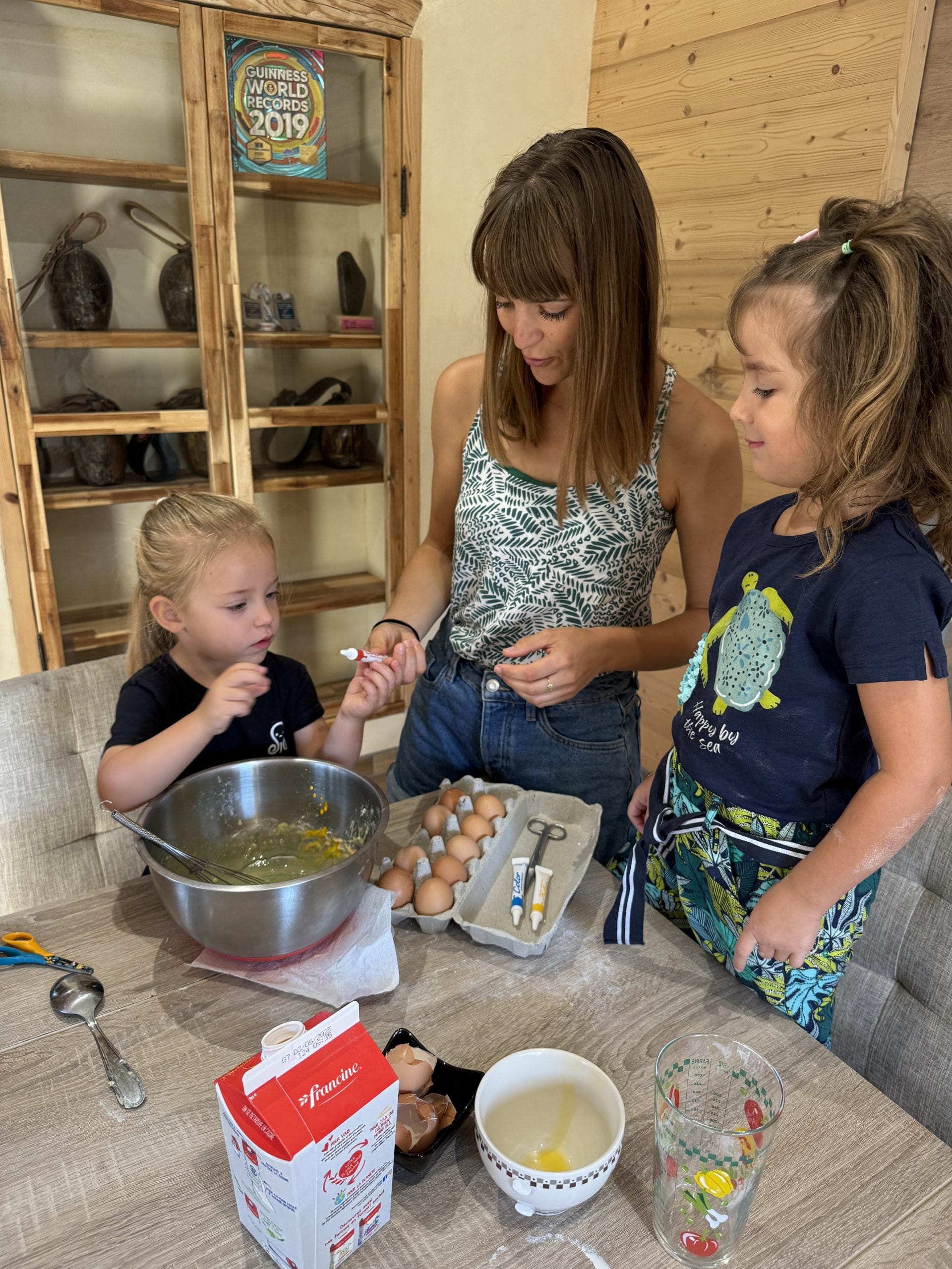 Famille préparant un gâteau ensemble dans la cuisine.