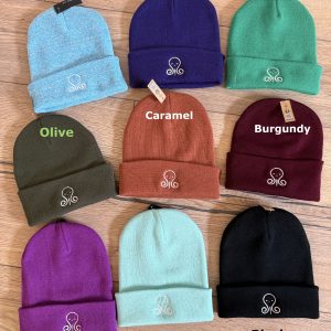 Collection de bonnets de différentes couleurs sur parquet.