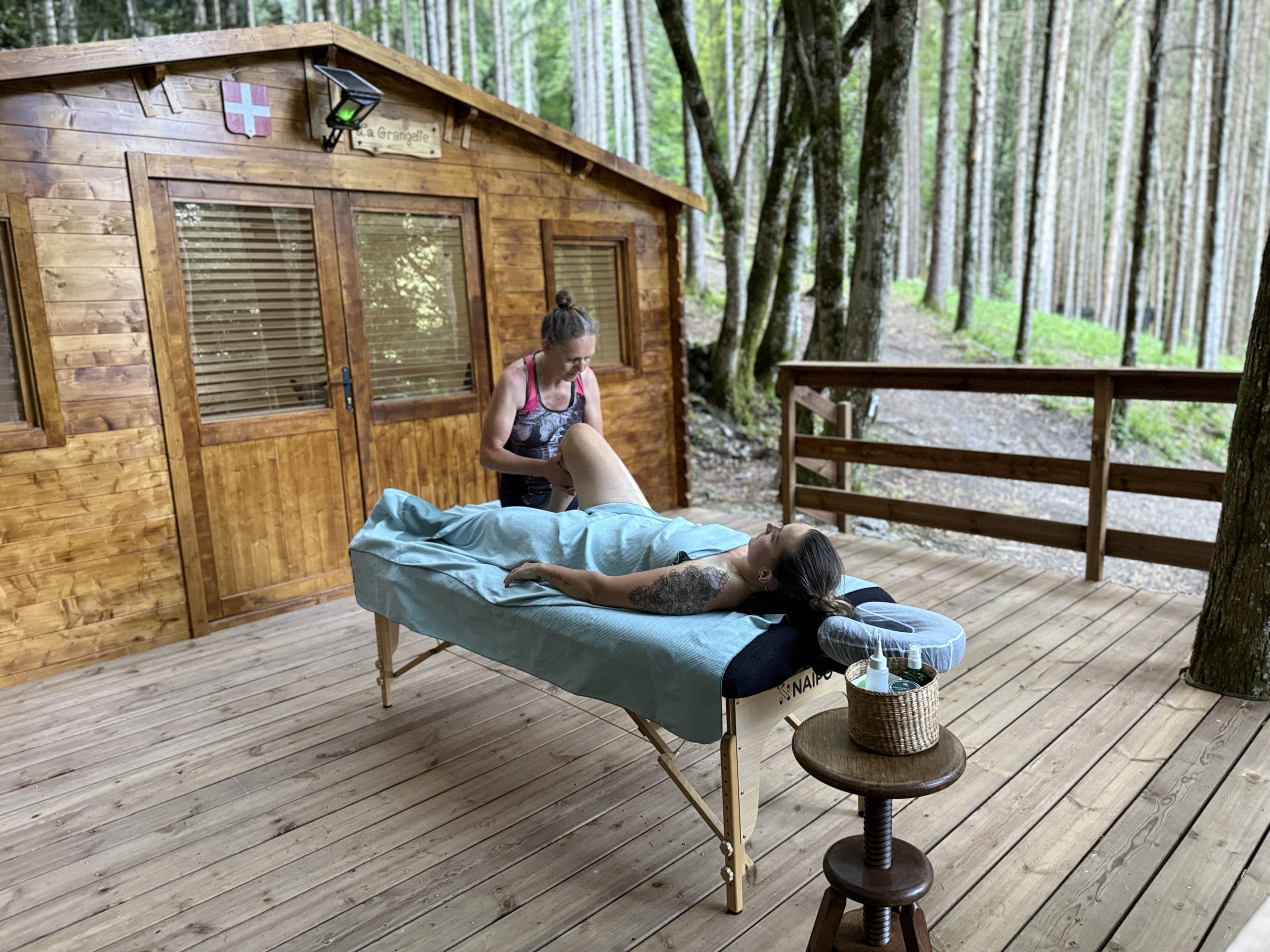 Massage extérieur devant un chalet en bois.