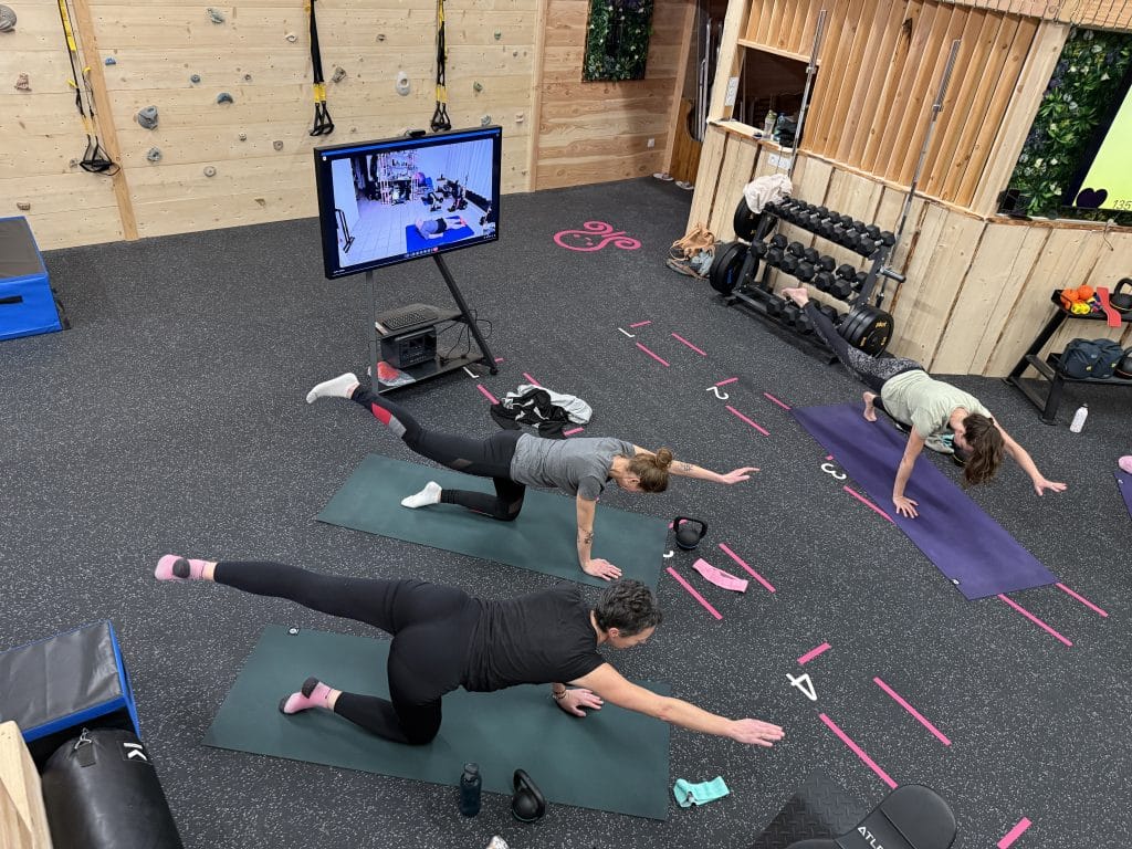 Groupe fait des exercices au sol en salle de sport.