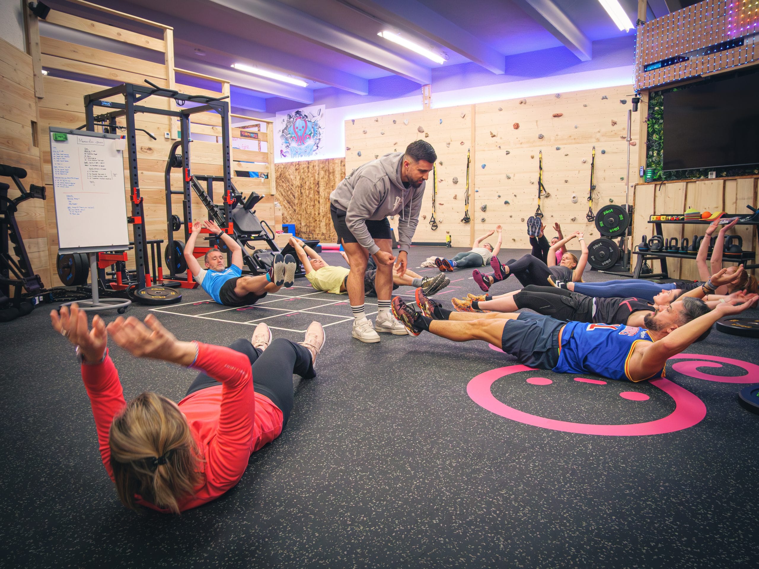 Entraînement en salle, personnes allongées font des exercices.