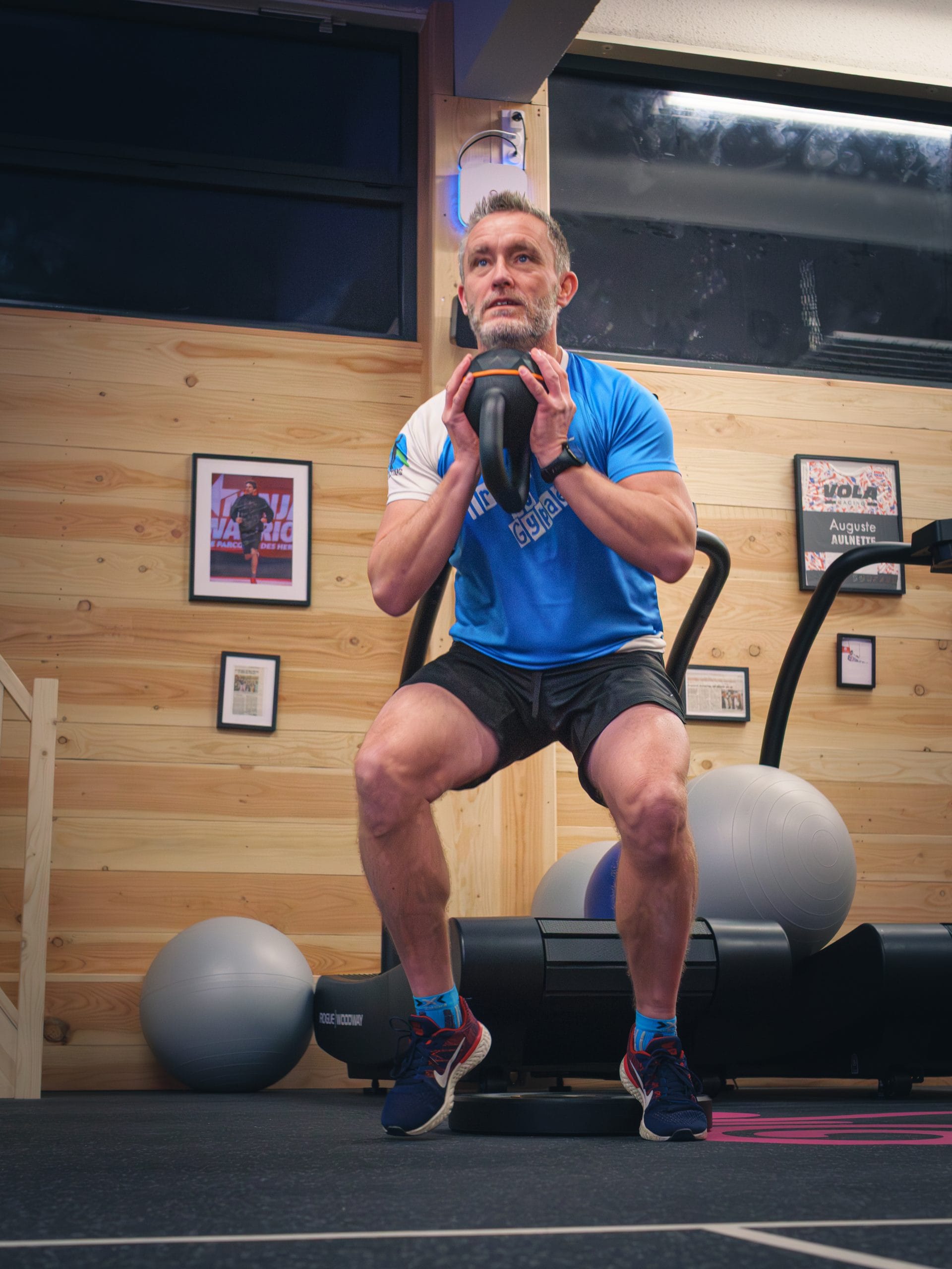 Homme faisant des squats avec un kettlebell.