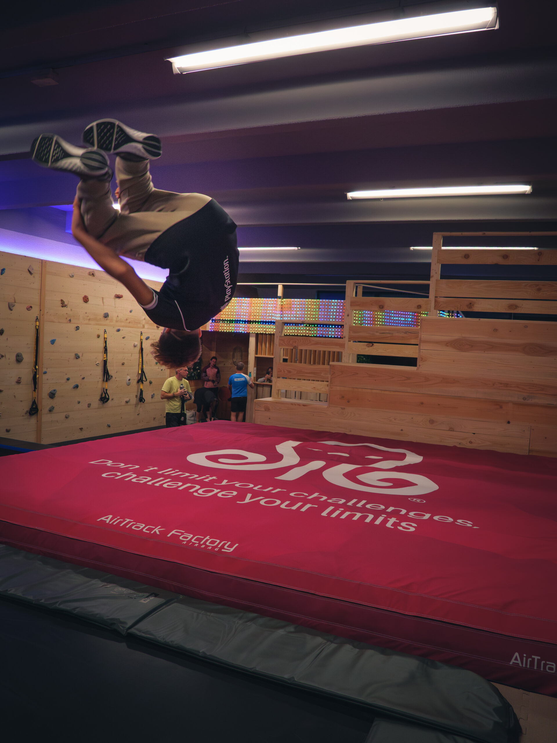 Personne effectuant un saut périlleux arrière en salle sur un airbag.
