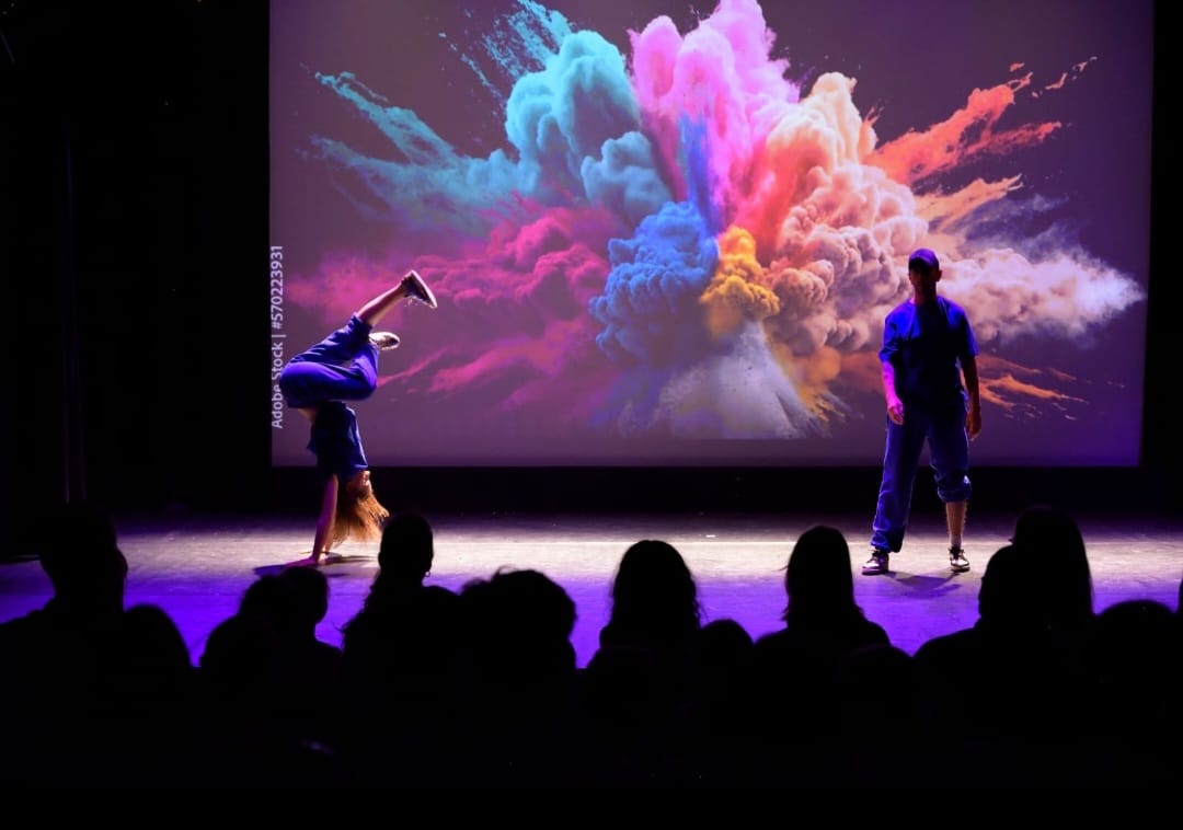 Danseurs sur scène avec explosion de couleurs