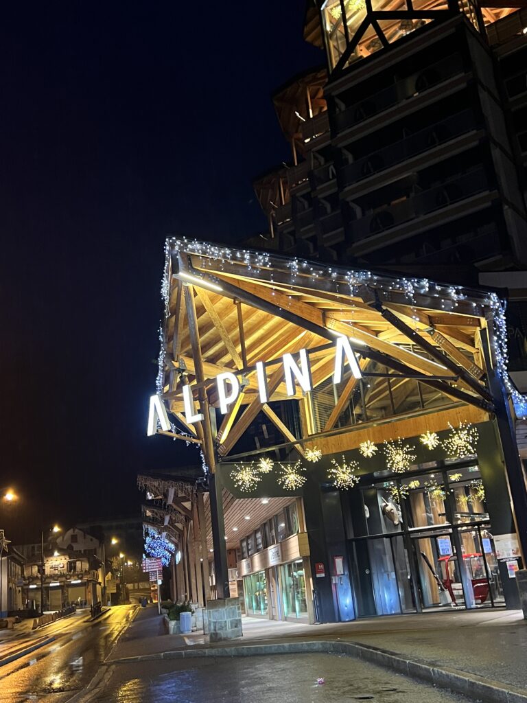 Façade éclairée de l'hôtel Alpina la nuit