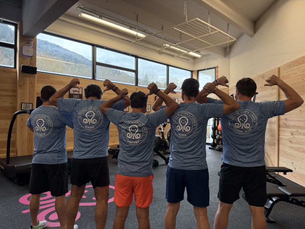 Cinq hommes en salle de sport bras fléchis