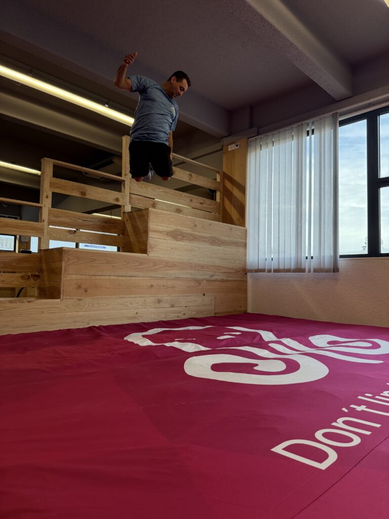 Homme sautant d'une mezzanine sur un matelas rouge