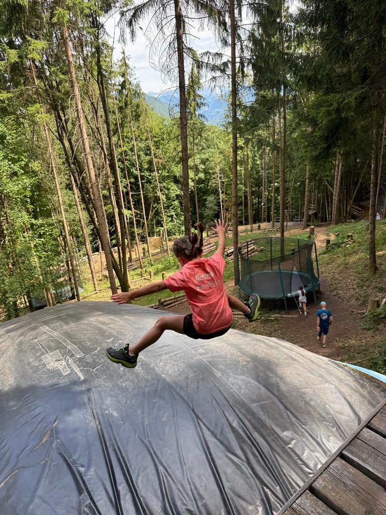 Enfant sautant sur un coussin gonflable en forêt